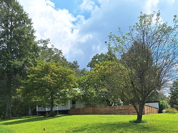 View up to side porch off Master BR, & the fence put on back of home beside back deck, & can house, also showing apple tree
