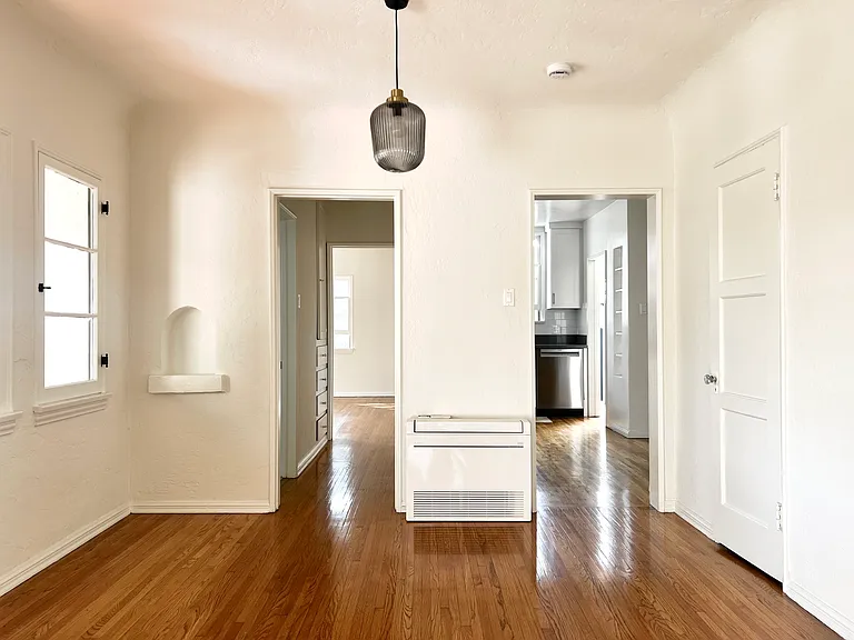 Dining room with wall of windows and original oak wood floors.
