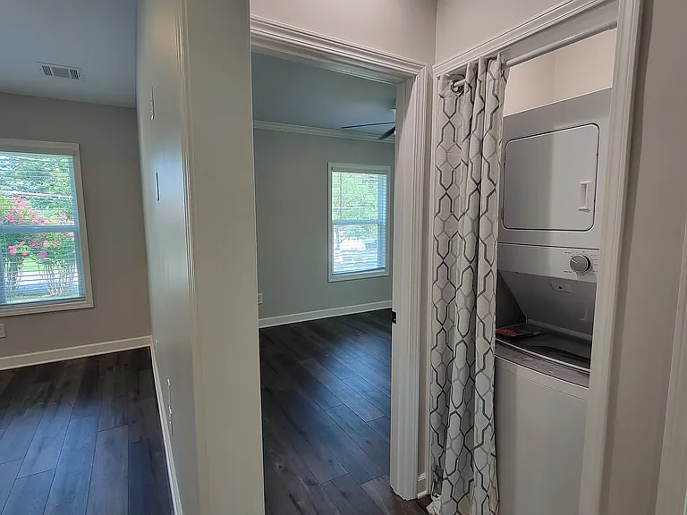 View to hallway, which connects living room to bedrooms, bathroom, and laundry area -- laundry machines included.