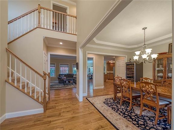 Enter the spacious two story foyer that opens to the modern design of this home.  Notice the custom trim work, hardwood flooring