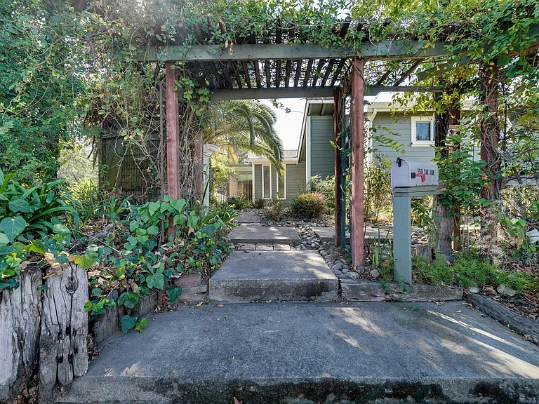 Path to front door. Mailbox with arched vine walkway.