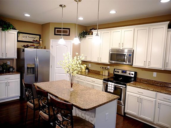 Corner walk-in pantry and staggered, crowned cabinets.