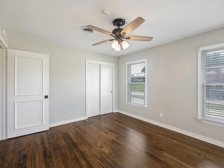 Unfurnished bedroom with dark hardwood / wood-style floors and ceiling fan