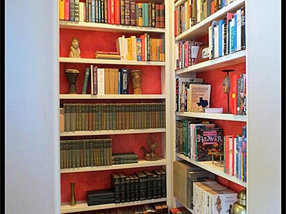 Lit arched bookcases built-in to the hallway leading to the master bedroom from the living room.