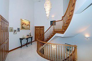 3 level grand foyer with curved staircase overlooking waterfall in lower level