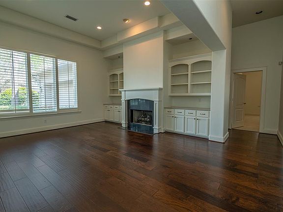 The formal living room has the first of two fireplaces, and built in shelving.