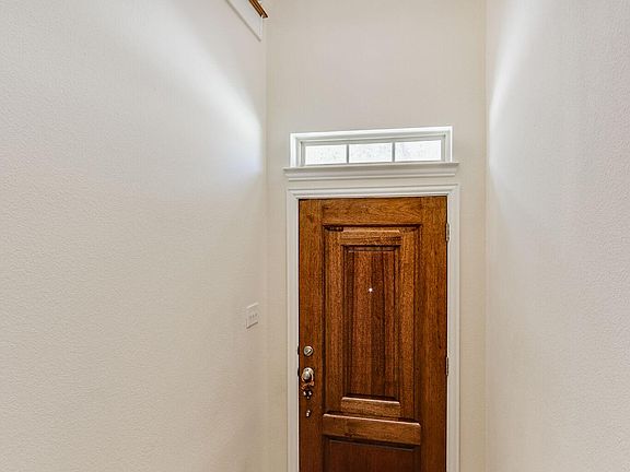 Foyer w wood floors and high ceiling.
