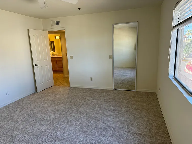 Bright and large Bedroom with mirrored door into walk-in closet.