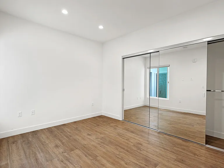 Bedroom with Large Mirrored Closet and Vinyl Flooring