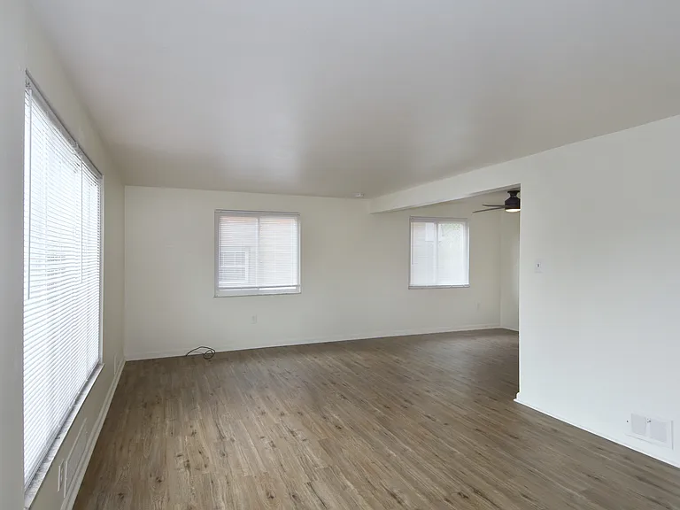 Freshly painted spacious living room with all-new luxury vinyl plank flooring and mini-blinds throughout unit.