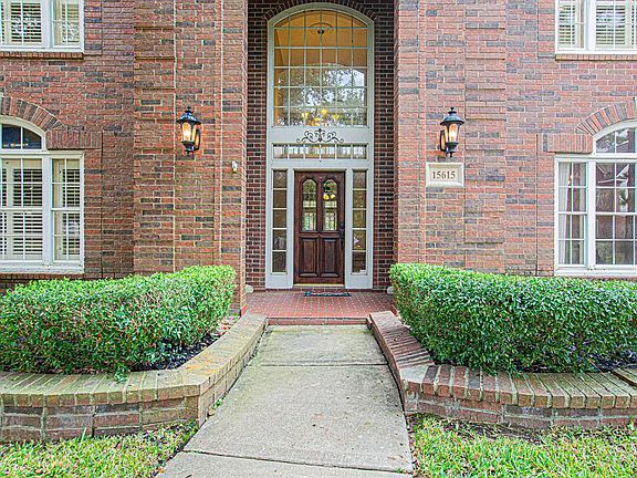 Such a timeless front exterior with covered front porch, arched windows and coach lights!