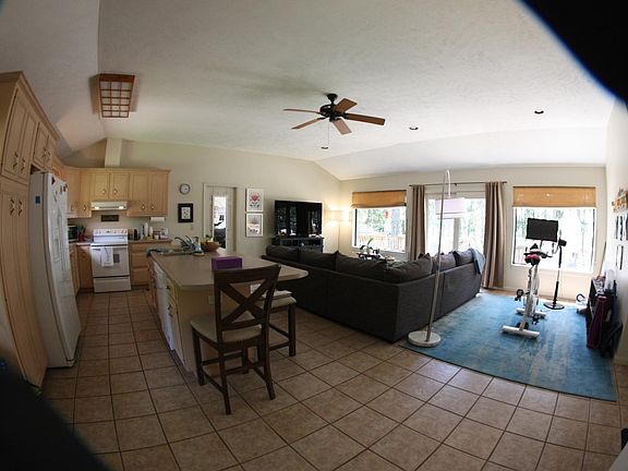 Living area and kitchen with sliding glass doors that open onto deck.