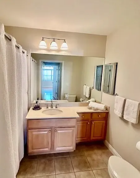 Modern, newly-painted bathroom with ceramic tiles and granite counter top