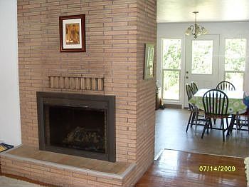 Beautiful fireplace divides living room from dining room.