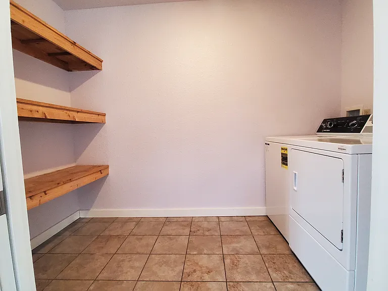 Laundry room with additional storage shelving