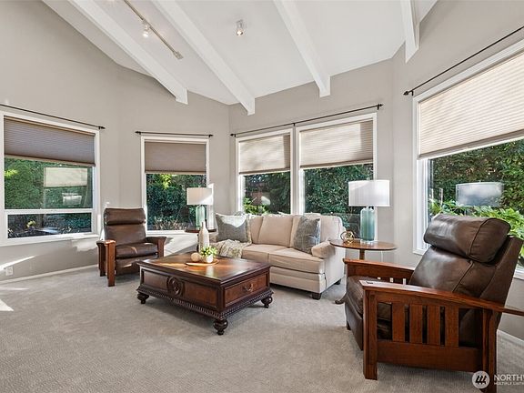 Spacious living room -- dramatic vaulted shed ceiling with exposed beams & designer track lighting, an expansive bank of windows providing plenty of natural light.>