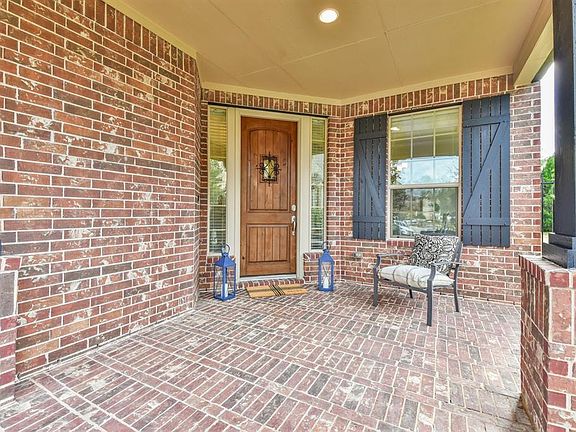 Inviting and fabulous entryway and front porch with custom wood front door with stylish wrought iron detailing!
