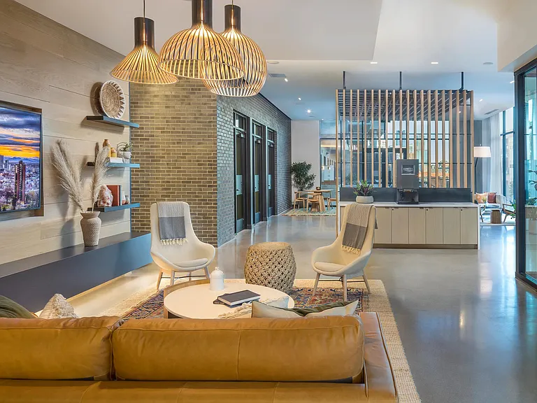 Indoor-outdoor bar and lounge area with kitchen and flat screen TVs.