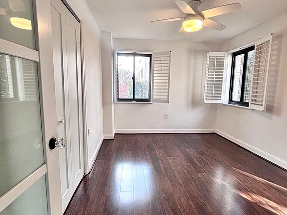 Large bedroom with a private view, two windows, and a wooden floor.