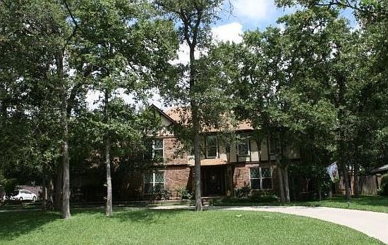 Mature trees lead to the front.