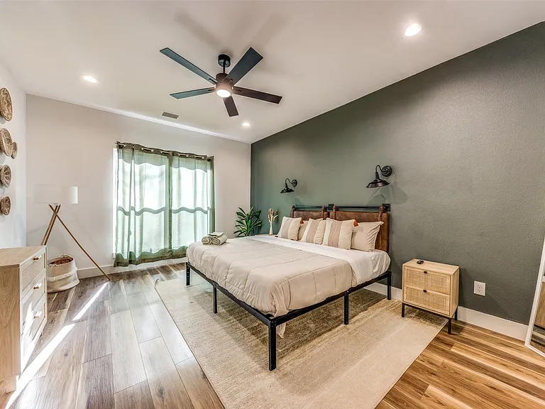 Spacious room featuring wood-finish flooring, a contemporary ceiling fan, and recessed lighting