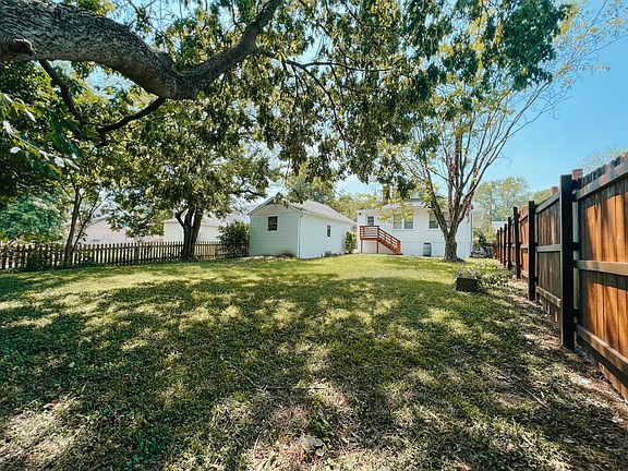 Large fenced backyard with mature trees