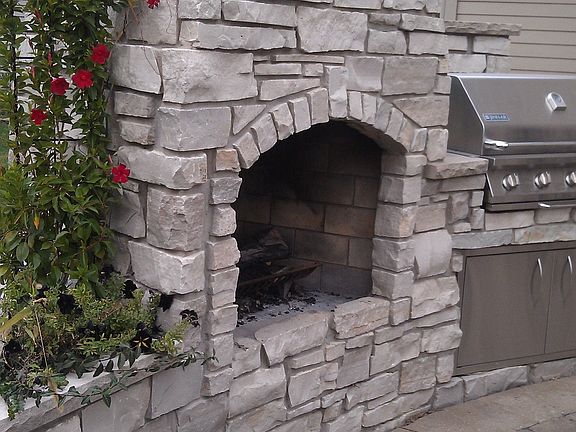 Amazing 2 story stone fireplace and stainless steel built in grill and planter