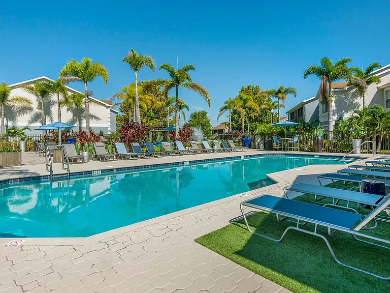 Relax in the sparkling resort-style pool at Soleil Blu Apartments, St Cloud, FL. Enjoy poolside lounging, lush palm trees, and a serene outdoor setting, perfect for unwinding.