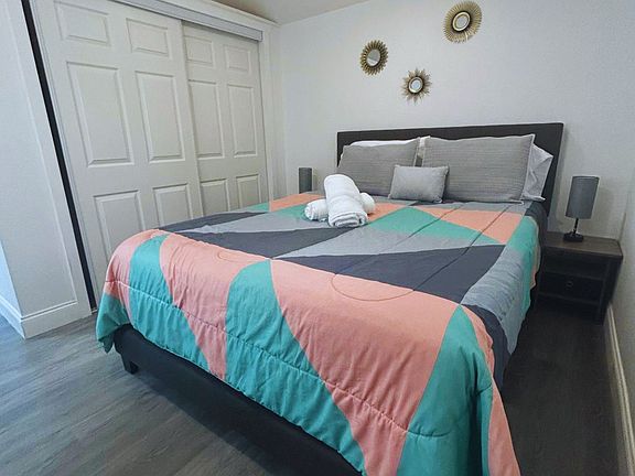 Room with large closet, decor pieces, towels and natural light window.