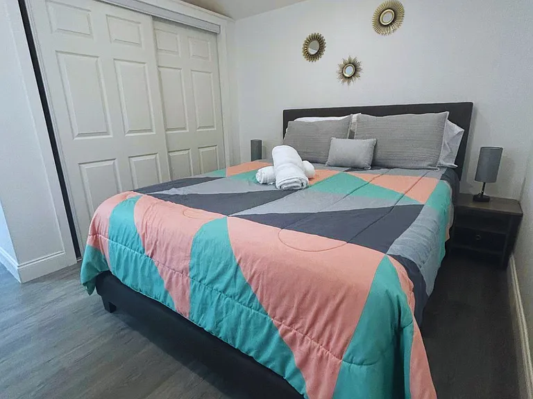 Room with large closet, decor pieces, towels and natural light window.