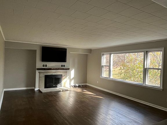 Family room with hardwood floors and wood burning fireplace.