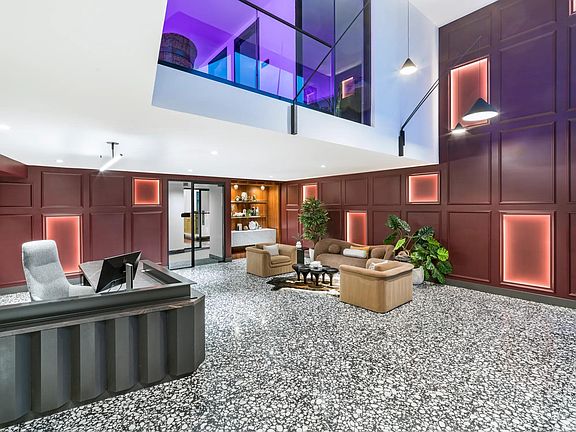 A bold lobby design welcomes you with layered textures, colorful lighting, and plush lounge seating.