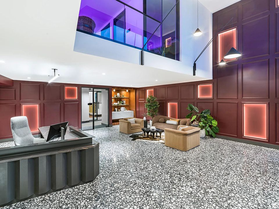 A bold lobby design welcomes you with layered textures, colorful lighting, and plush lounge seating.