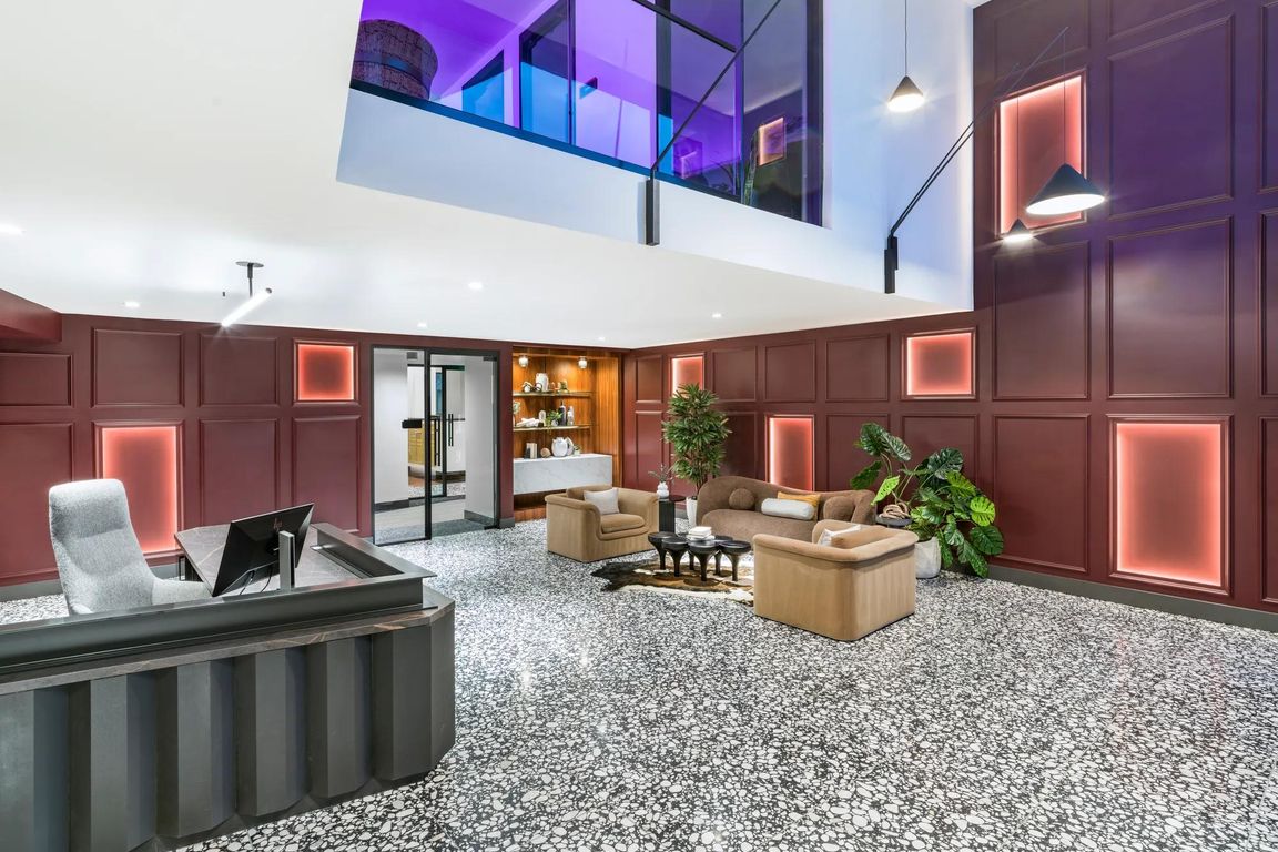 A bold lobby design welcomes you with layered textures, colorful lighting, and plush lounge seating.