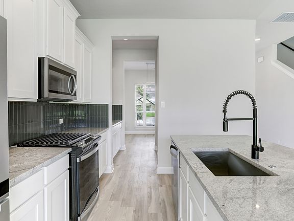 Stunning kitchen with a tile backsplash, granite countertops, and stainless appliances.