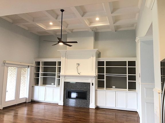 Living Room with coffered ceiling. Prewired for HDTV above Fire place. Fire place has remote. Ceiling fan and light have remote. Hardwood floors.