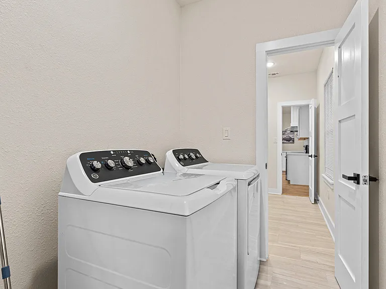 Dedicated laundry area with full-size washer and dryer, positioned off the main hallway for easy access.