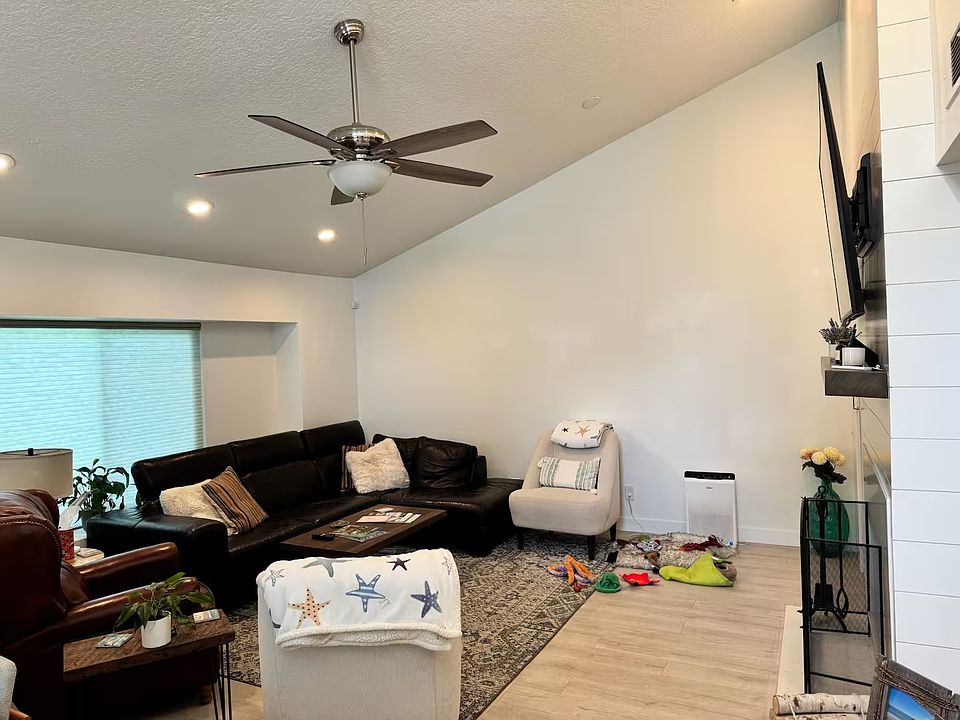 Living Room with Cathedral Ceilings, Ceiling Fan, and Big Screen TV