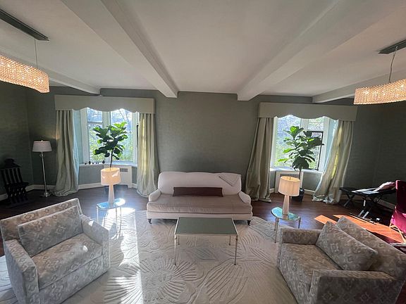 Hand-applied custom wall work. Beams. Swathed in light from windows on three sides. Very large formal living room