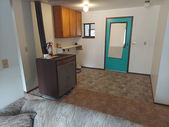 room or artists studio looking eastward toward storage room on other side of green door. wood stove