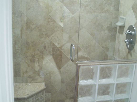 Master shower travertine, frameless glass, seating, multi jets