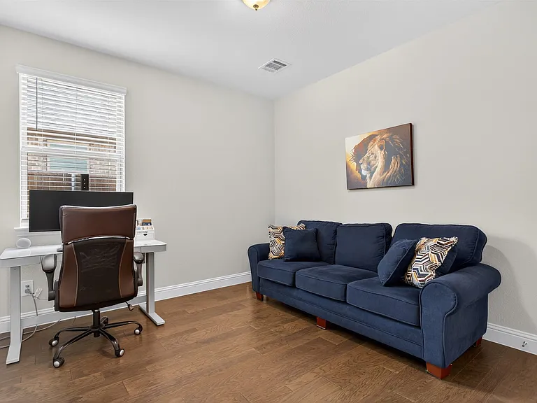 Versatile room featuring wood-finish flooring, light-toned wall paint, and white trim molding