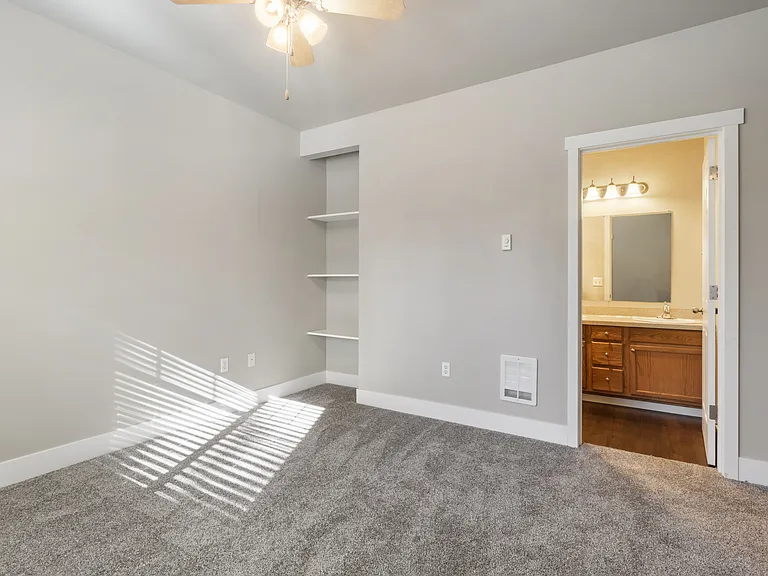 Primary bedroom with attached bath and built-in shelving