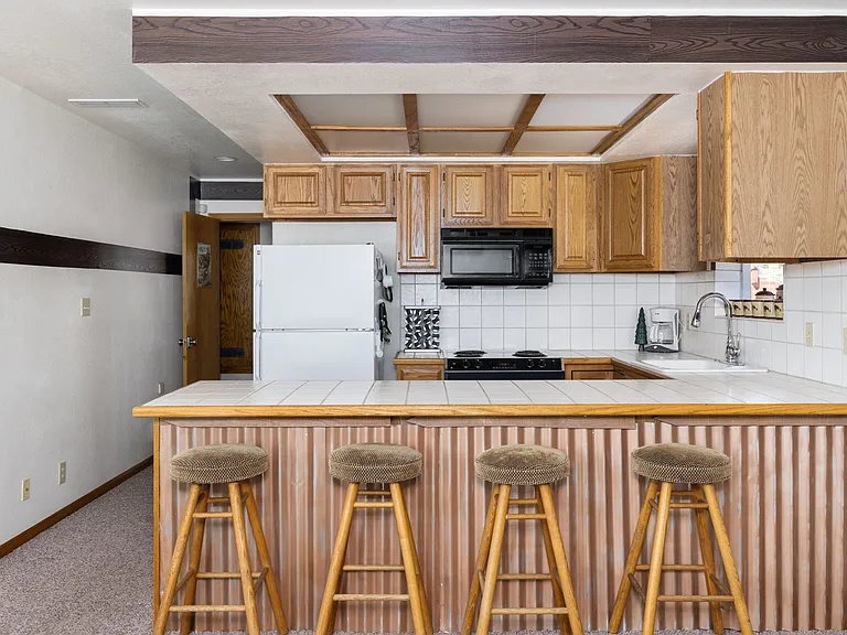 Upstairs fully stocked kitchen, island bar and door to outside Hot Tub and 360 walk around HUGE deck.