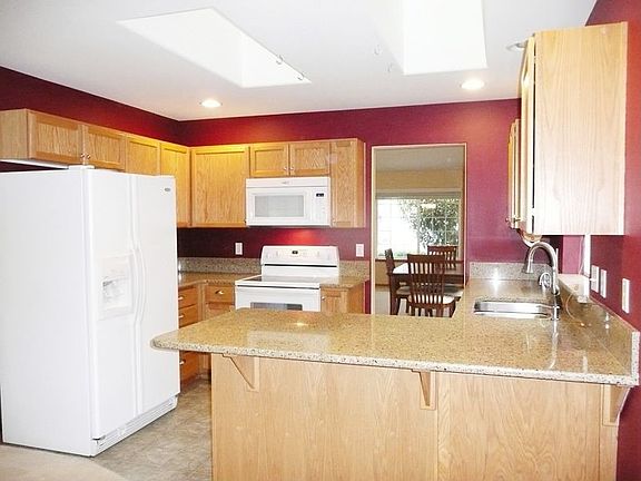 Upgraded cabinets, hardware and Silestone granite counters and backsplash. Breakfast bar and kitchen has two skylights that allow for a bright kitchen. All appliances stay! Lots of storage. 