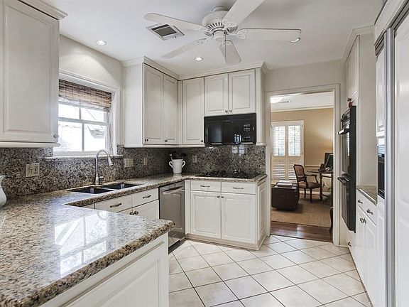 Kitchen features granite countertops & backsplash, double ovens, and a built in refrigerator.