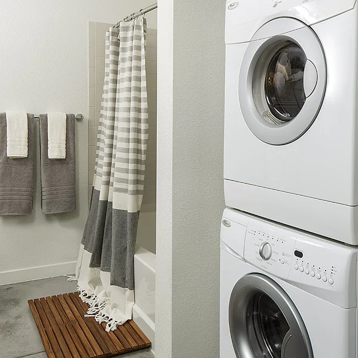 Apartment Bathroom with soaking tub and in-home washer and dryer.