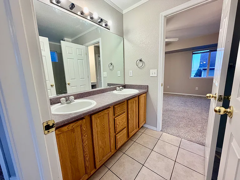 Well-designed Jack-and-Jill bathroom featuring a dual-sink vanity with extended countertop space, separate tub/shower and toilet area, and convenient access from both upstairs bedrooms, providing privacy and functionality for everyday use.
