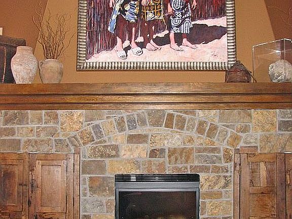 Gorgeous newly stoned fireplace flanked by antique doors
