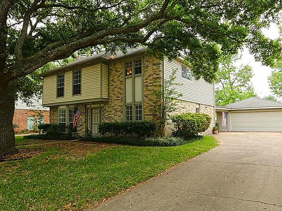 Extended driveway leads to a 2-car detached garage.